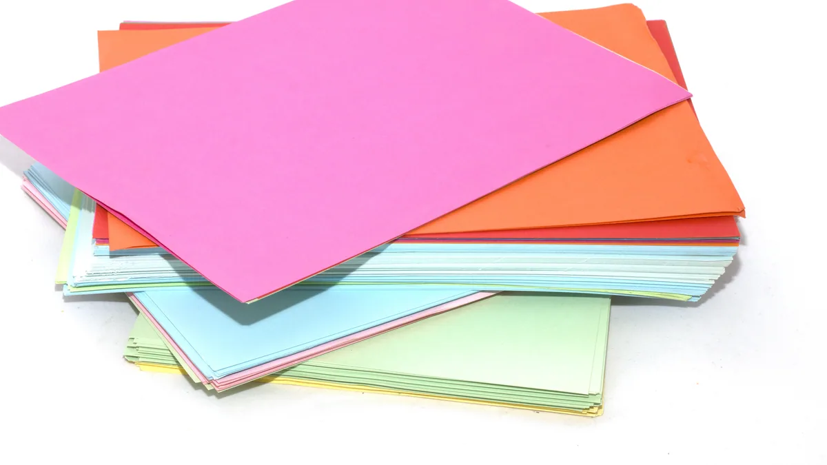 A stack of coloured paper sheets on a white background